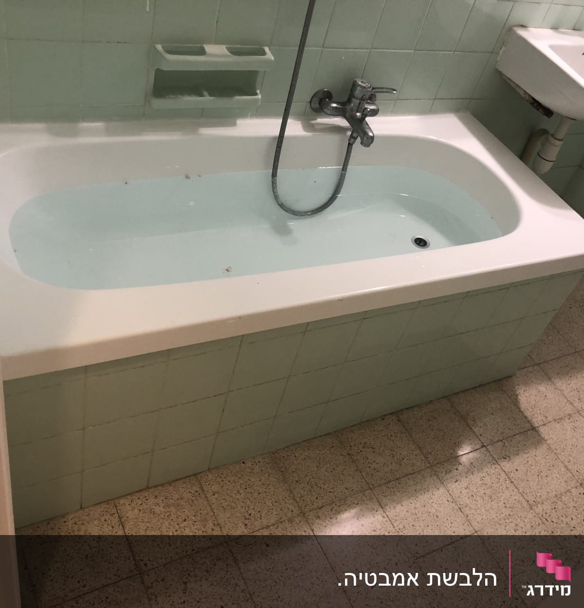 אמבטיה עם חיפוי אריחים ירוקים וברז מקלחת